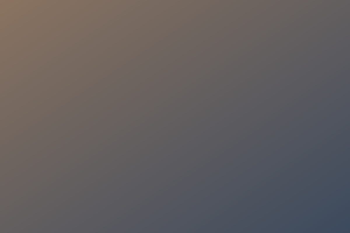 A loaded container ship leaving port at sunset